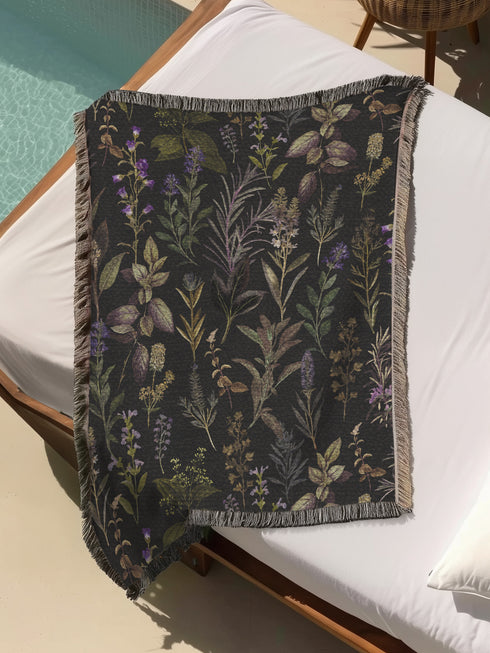 Forest green cotton throw blanket with woven silver moon phases and golden sun motifs, finished with multicolored fringe trim.